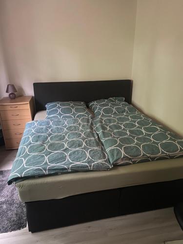 un letto in una camera da letto con copriletto e cuscini di 3 Zimmer Apartment a Bayreuth