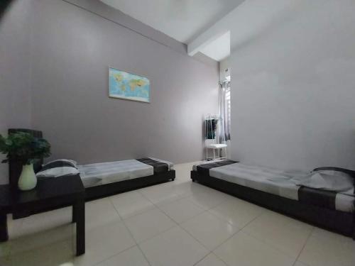 a room with two beds and a window in it at 3 rooms (aircond) in Muar Town in Muar