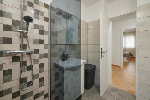 uma casa de banho com um lavatório e um chuveiro em Trau em Trogir