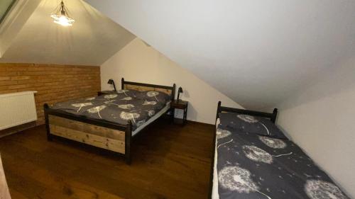 two beds in a room with a attic at Apartmany FABRIK in Vysoká nad Kysucou