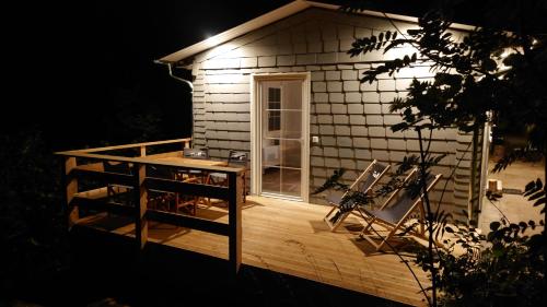 a small house with a deck at night at Ruhiges Ferienhaus mit Sauna: Hellaberg III in Langenbach