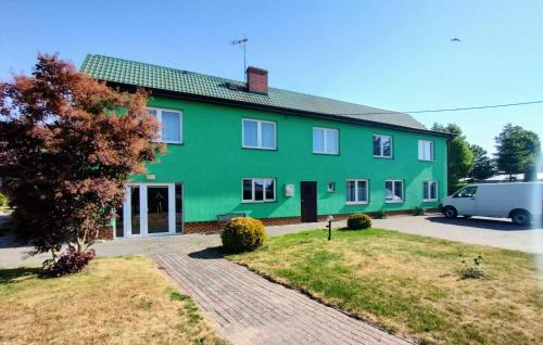 een groen huis met een busje ervoor geparkeerd bij Agroturystyka Osieki in Osieki