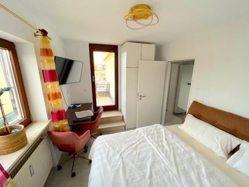 1 dormitorio con cama, escritorio y silla en Marc‘s Rooms en Múnich
