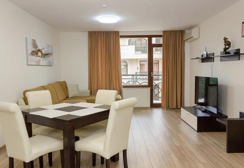 a living room with a table and chairs and a television at Golden Sands 1BD Apartment by Flat Mаnager in Varna City