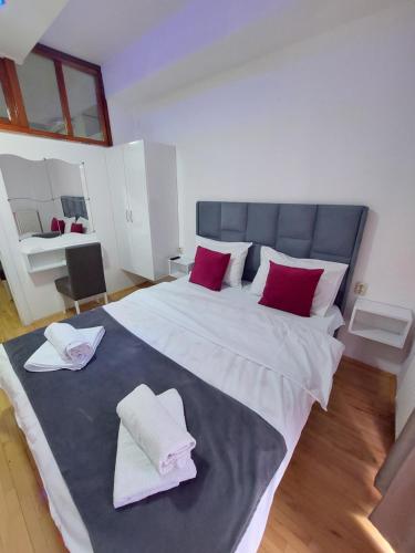 1 dormitorio con 1 cama grande con almohadas rojas y blancas en Petreski Apartments 1, en Ohrid