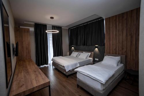 een hotelkamer met 2 bedden en een tafel bij GRIFFON BAR FOOD APARTMENTS in Struga