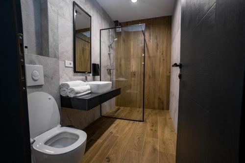 een badkamer met een toilet, een wastafel en een douche bij GRIFFON BAR FOOD APARTMENTS in Struga