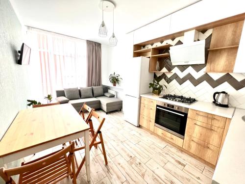 een keuken en een woonkamer met een tafel en een bank bij VIP Apartment in a complex Semycvit in Lviv