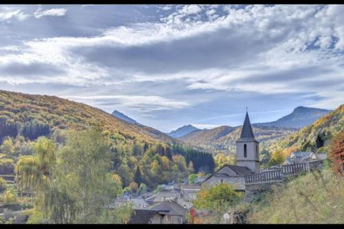 a church in the middle of a valley with trees at Grand gîte au cœur des Pyrénées - Ariège Mijanes in Mijanès