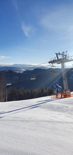 a ski lift on top of a snow covered slope at Apartamenty na Soszowie, Wisła - widokowe miejsce z Balią & Prywatną Sauną, obok stoku narciarskiego i Bike Parku, dla max 16 osób in Wisła