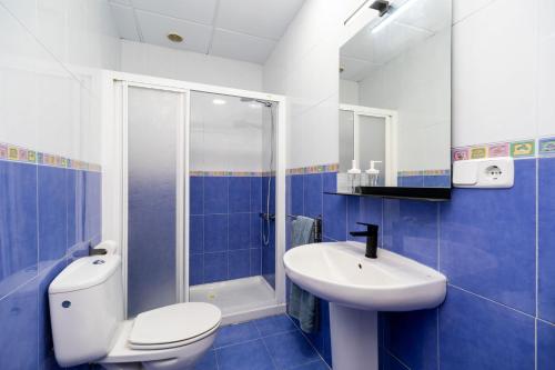 a blue and white bathroom with a toilet and a sink at La Casa Verde in Almería
