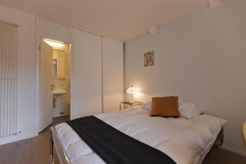 a bedroom with a large white bed with a brown pillow at Baseltor Hotel & Restaurant in Solothurn