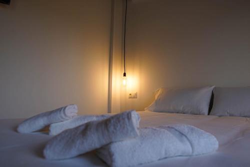 a white bed with white sheets and pillows on it at Villa Carmensin in Deltebre