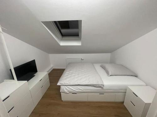 Buxtehude*Wohnung*100qm*6 Schlafplätze*NEU* في بوكستيهود: غرفة نوم بيضاء مع سرير وتلفزيون
