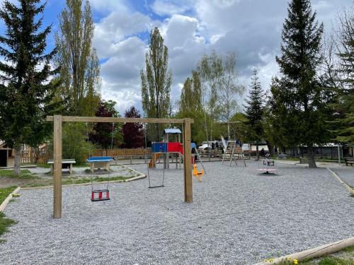 a playground with play equipment in a park at Appartement 6 couchages, Tout confort, pieds des pistes, ménage & linge de maison inclus in Montclar