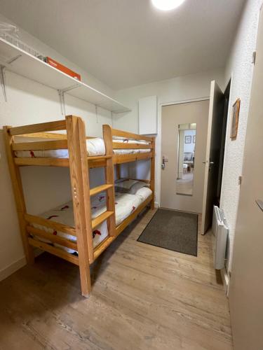 a room with two bunk beds and a hallway at Appartement 6 couchages, Tout confort, pieds des pistes in Montclar