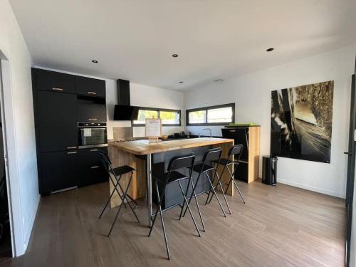 eine Küche mit Tisch und Stühlen in einem Zimmer in der Unterkunft Villa Pura Vida in Magescq