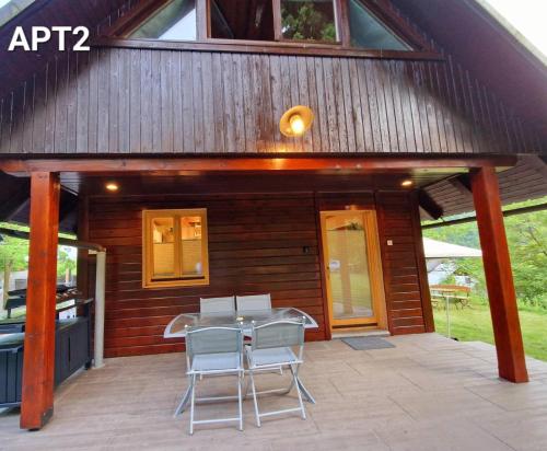 Cette cabane en bois dispose d'une terrasse avec une table et des chaises. dans l'établissement Alpine Village Home, à Bohinj