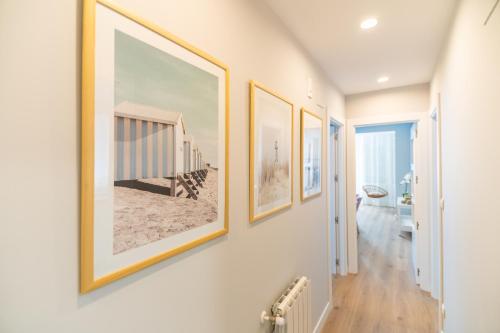 a hallway with three framed pictures on the wall at VILLA MARTA - Apartamentos céntricos junto al mar in Castro-Urdiales
