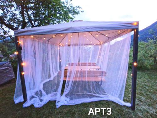 a gazebo with a chair under it with lights at Alpine Village Home in Bohinj