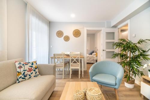 een woonkamer met een bank, een stoel en een tafel bij VILLA MARTA - Apartamentos céntricos junto al mar in Castro-Urdiales