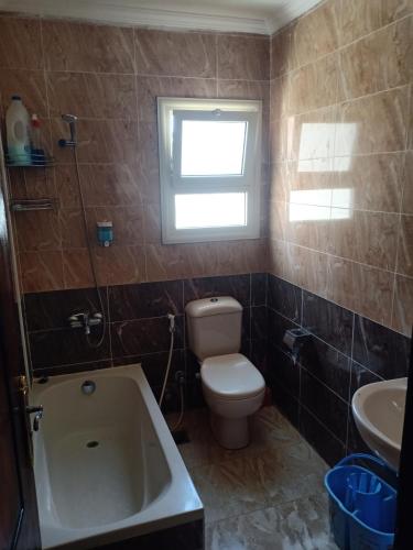 uma casa de banho com um WC, um lavatório e uma banheira em فيلا للايجار فى العين السخنة قرية لاجولى em Ain Sokhna
