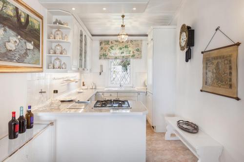 a kitchen with white walls and a counter with a stove at Villa Florinda in Bardolino