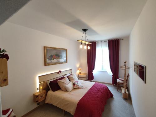 a bedroom with a large bed with a red blanket at Tirano Express Apartments in Tirano