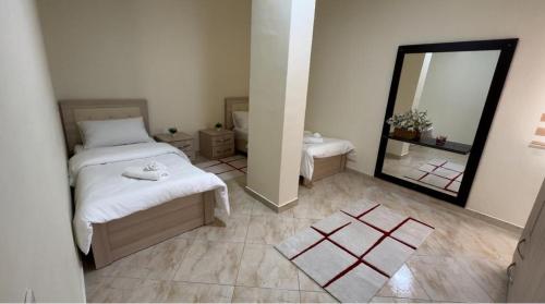 a bedroom with two beds and a large mirror at Villa Apartments S&F City Centre in Tirana
