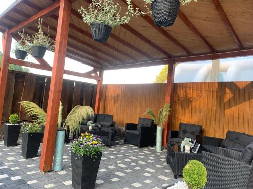 a patio with black furniture and potted plants at Приватна садиба Шаянське джерело in Shaian