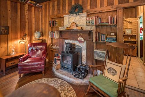 a living room with a fireplace and a chair at Country Woods Inn in Glen Rose