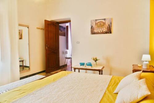 a bedroom with a large bed and a mirror at Arcu de Chelu B&B in Modolo