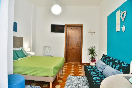a bedroom with a green bed and a couch at Arcu de Chelu B&B in Modolo