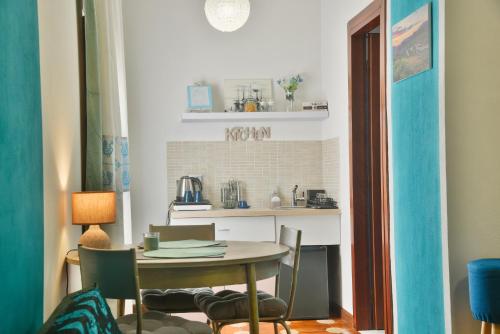una mesa y sillas en una habitación con cocina en Arcu de Chelu B&B, en Modolo