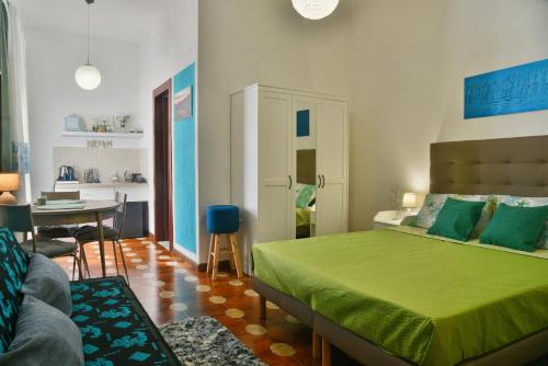 a bedroom with a green bed and a dining room at Arcu de Chelu B&B in Modolo