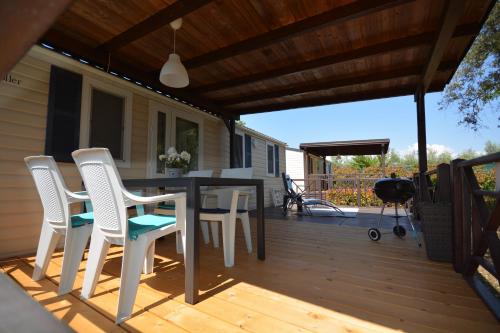 a patio with a table and chairs on a deck at West Coast Mobilhome with XXL Terrace in Naturist Resort Solaris FKK in Poreč