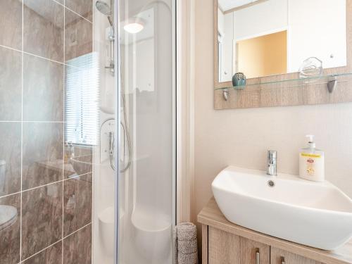 uma casa de banho com um lavatório e um chuveiro em Tradmach Lodge em Patrington