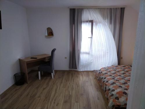 a bedroom with a bed and a desk and a window at Nice view-Plitvice in Korenica