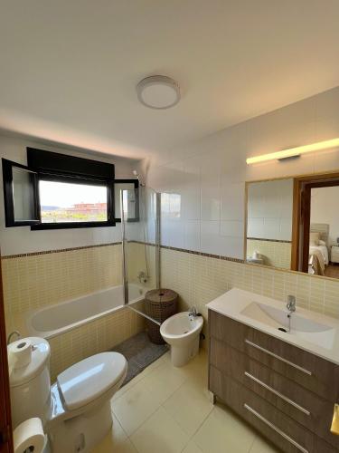 a bathroom with a toilet and a tub and a sink at Villa Do Juano in Lajares