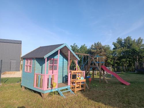 una pequeña casa con un tobogán y un parque infantil en Domki Halo Morze en Jastrzębia Góra