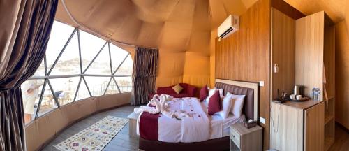 a bedroom with a bed and a large window at Moon Magic Valley in Wadi Rum