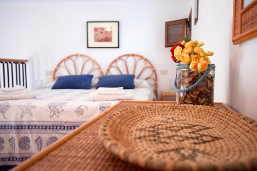 a room with two beds and a table with a bowl of fruit at Casa Zu Peppino in Lipari