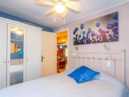 a bedroom with a white bed with a blue pillow at Apartamento Cool en calpe!centro Turístico y playa in Calpe