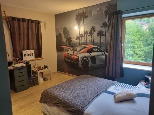- une chambre avec un lit et une voiture sur le mur dans l'établissement Belle Villa en Ardèche Verte, à Vocance