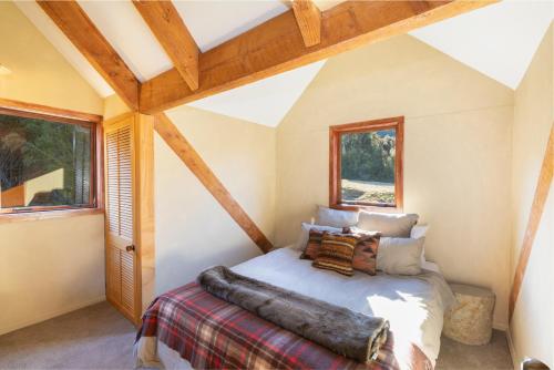 1 dormitorio con 1 cama en una habitación con techos de madera en Lyford's Boutique Retreat - Relax & Enjoy, en Mt Lyford