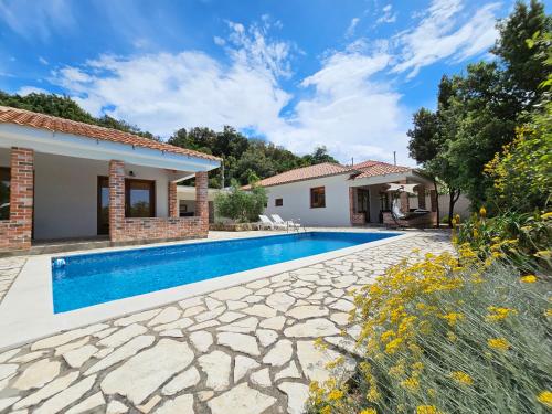 a villa with a swimming pool and a house at Holiday homes Sintija in Rab