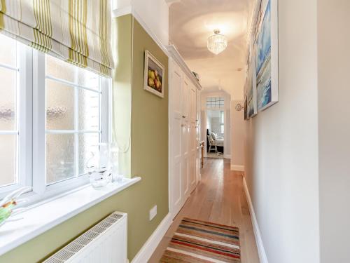 um corredor com paredes verdes e uma janela em Crossways Mansions em Bexhill