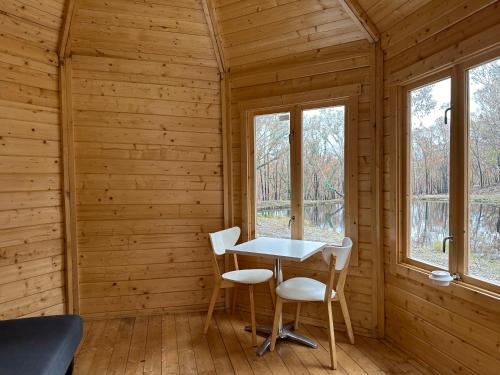 a room with a table and chairs in a log cabin at Off-the-grid Mountain hideaway in Hill End