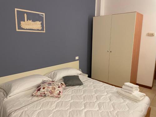 a bedroom with a bed and a cabinet and towels at Sportland in Colle Val D'Elsa