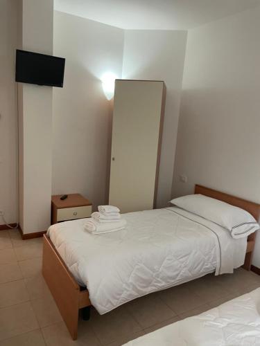 a bedroom with a bed with white sheets and a mirror at Sportland in Colle Val D'Elsa